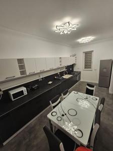 cocina con mesa y sillas y cocina con encimera en Comfy & Cozy Apartment 3, en Rădăuţi