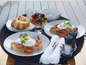 a table with three plates of breakfast food on it at Hotel Marshal Garni in Belgrade