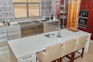 una cocina con una gran isla blanca en Mseleku Villa, en Harrismith