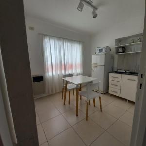 a small kitchen with a table and a refrigerator at Dpto Estudio in Gualeguaychú