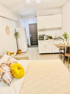 a kitchen and living room with a bed and a table at Like Home Apartments in Almaty