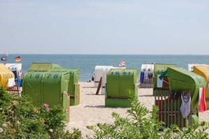een rij strandstoelen en schuilplaatsen op het strand bij Gästehaus "Gorch Fock" in Wyk auf Föhr