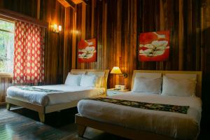 um quarto com 2 camas, uma janela e pinturas em tierras altas casa grande em Bambito