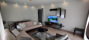 a living room with a couch and a flat screen tv at First Avenue Mall & Residence in Istanbul