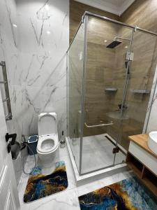 a bathroom with a glass shower and a toilet at Villa Karakol in Karakol