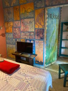 a room with a wall covered in murals at Pousada Babel in Rio de Janeiro