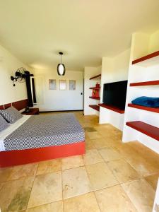 a bedroom with a bed and a flat screen tv at Kitesurf Oasis Maracajaú in Maracajaú
