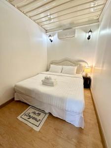 a small bedroom with a bed with a white bedspread at Marc Hotel Maesai in Ban Sam Mana