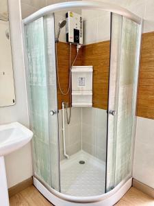 a shower with a glass door in a bathroom at Marc Hotel Maesai in Ban Sam Mana