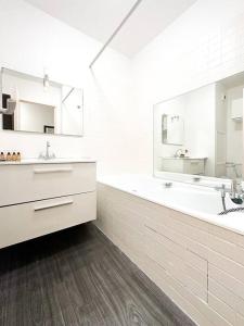 a white bathroom with two sinks and two mirrors at Studio#Gare Montparnasse#Galeries Lafayette#2pers. in Paris