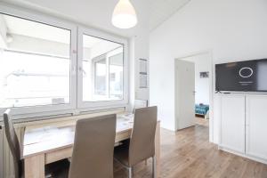 una sala da pranzo con tavolo, sedie e finestra di nJoy! Sunny & Spacious - Balkon - WLAN - Parkplatz - perfekt für Work & Travel a Göppingen