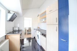 a kitchen with white cabinets and a washer and dryer at nJoy! Sunny & Spacious - Balkon - WLAN - Parkplatz - perfekt für Work & Travel in Göppingen