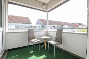 un balcón con 2 sillas y una mesa en el balcón en nJoy! Sunny & Spacious - Balkon - WLAN - Parkplatz - perfekt für Work & Travel en Göppingen