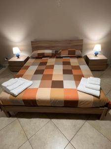 - une chambre avec un lit en damier dans l'établissement Nonna Croce Home, à San Giovanni Gemini