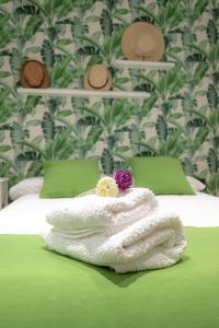 a pile of white towels sitting on a bed at Zenete Terral Málaga in Málaga