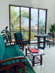 sala de estar con sillas y mesas y balcón en Spacious 2 Bed Room Apartment en Matara