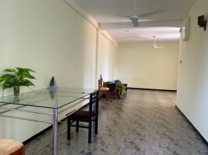 una habitación vacía con mesa de cristal y sillas en Spacious 2 Bed Room Apartment en Matara