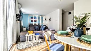 een woonkamer met een bank en een tafel bij Blue Lagoon 150m-2 minuta hoda od centra, mogucnost za parking-apartmani-nsmilos in Novi Sad +56 foto's