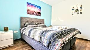 - une chambre avec un lit aux murs bleus dans l'établissement Blue Lagoon in city center - apartmani-nsmilos, à Novi Sad
