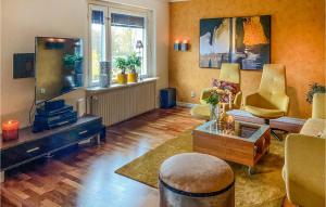 - un salon avec une télévision, un canapé et une table dans l'établissement Gorgeous Apartment In Huskvarna With Kitchen, à Huskvarna
