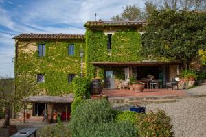 um edifício coberto de hera verde com um pátio em Agriturismo & Winery Il Bacio em Tavarnelle in Val di Pesa