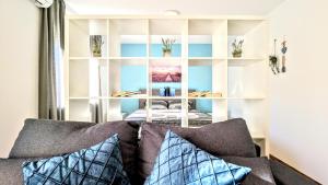 een woonkamer met een bank met kussens bij Blue Lagoon 150m-2 minuta hoda od centra, mogucnost za parking-apartmani-nsmilos in Novi Sad