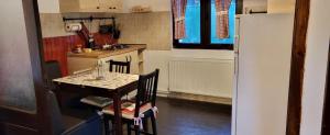 a small kitchen with a table and a refrigerator at Cabana Cotu lui Iepure in Trăisteni