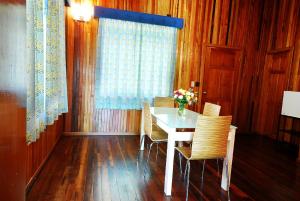 uma sala de jantar com uma mesa com cadeiras e um vaso de flores em tierras altas casa grande em Bambito