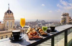 una mesa con un plato de comida y un vaso de cerveza en Smartr Madrid Chueca, en Madrid