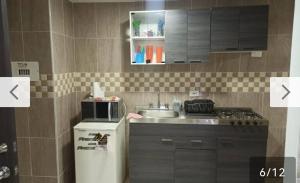 cocina pequeña con fregadero y fogones en Hermoso apartamento con excelente ubicación en Ibagué