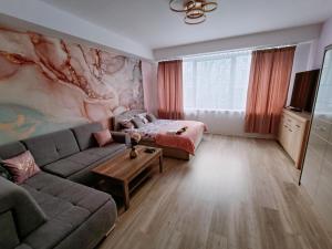 uma sala de estar com um sofá e uma mesa em Apartamenty Centrum- Wojska Polskiego em Słupsk