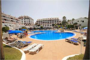 a large swimming pool with chairs and umbrellas at Parque Santiago II 160 by Tenerife Rental and Sales in Playa de las Americas