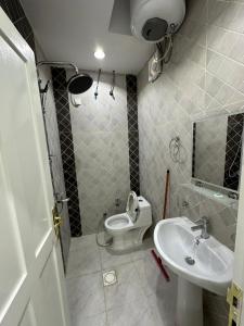 małą łazienkę z toaletą i umywalką w obiekcie برج موجان السكني التجاري w mieście Chamis Muszajt