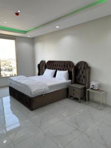 a bedroom with a large bed with a large window at برج موجان السكني التجاري in Khamis Mushayt