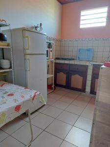 a kitchen with a white floor and a refrigerator at La villa du manguier in Le Vauclin