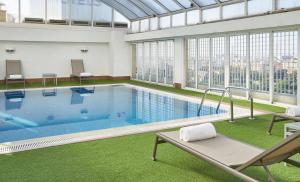 a large indoor pool with a view of the city at NH Valencia Center in Valencia