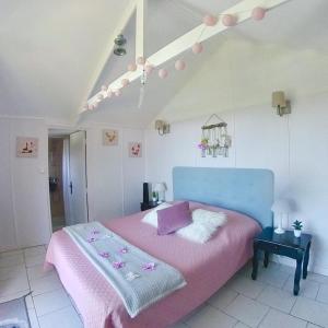 a bedroom with a pink bed with a blue headboard at Résidence île de beauté in Propriano