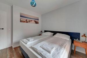 een slaapkamer met een groot wit bed en een tafel bij Apartament z widokiem na rzekę by Grand Apartments in Gdańsk