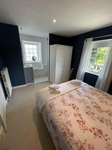 a bedroom with a large bed and two windows at Little Crugsillick in Veryan