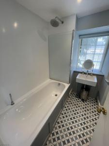 Baño blanco con bañera y lavamanos en Little Crugsillick en Veryan