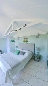 a large white bedroom with a large white bed at Résidence île de beauté in Propriano