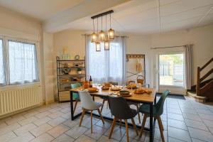 uma sala de jantar com uma mesa de madeira e cadeiras em Maison sur la route du Cognac em Saint-Même-les-Carrières