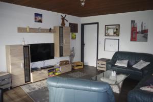 a living room with a couch and a flat screen tv at Ferienhaus Mitteldeich in Butjadingen
