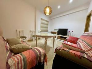 een woonkamer met een bank en een tafel bij Apartamento Almogávares in Córdoba