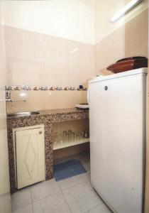 La cuisine est équipée d'un réfrigérateur blanc et d'un évier. dans l'établissement Résidence Mer et soleil, à Agadir
