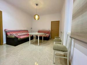 een woonkamer met een bank en een tafel en stoelen bij Apartamento Almogávares in Córdoba