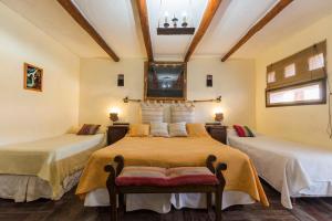 a bedroom with two beds and a ceiling at La Posada del Rio in Tilcara