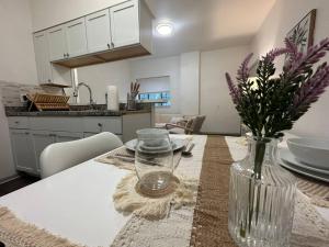 a kitchen with a table with a vase of flowers on it at GREAT VALUE Luxe Style Queen Beds WD Parking in Schenectady +27 photos