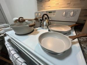 a stove with three pots and pans on top of it at GREAT VALUE Luxe Style Queen Beds WD Parking in Schenectady