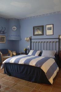 a bedroom with a large bed with blue walls at Hotel La Posada de Lalola in Buera